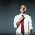 Eminem in einem weißen Hemd und roter Krawatte.